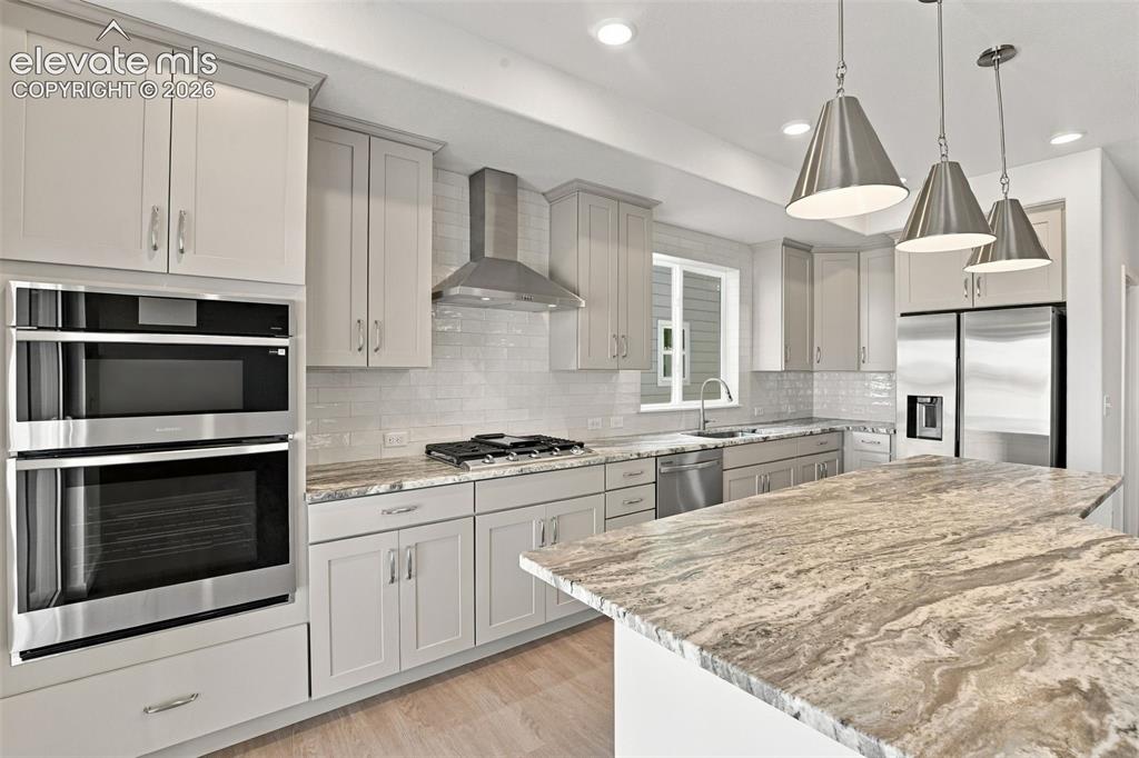 Image 11 of 50: Kitchen featuring shaker-style cabinetry, stone countertops, a stainless st