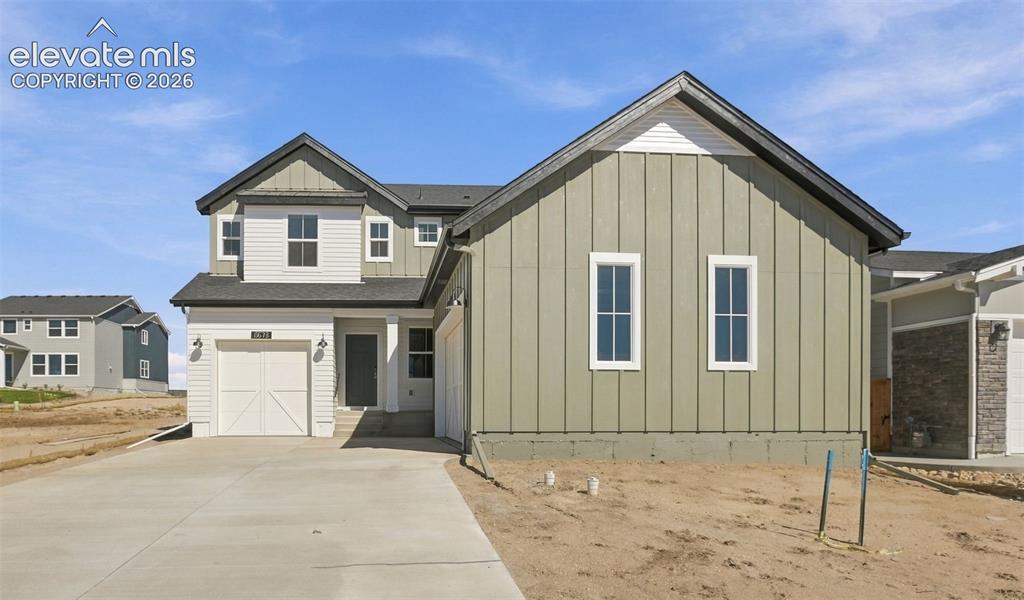 Image 2 of 50: Modern farmhouse exterior featuring vertical board-and-batten siding, contr