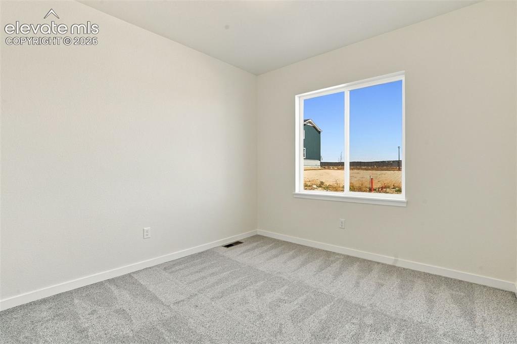 Image 20 of 50: Neutral-toned interior space featuring light-colored wall paint, carpeted f
