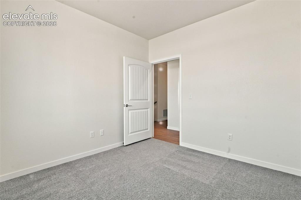 Image 21 of 50: Interior room featuring neutral-toned carpeting, white walls, and a two-pan