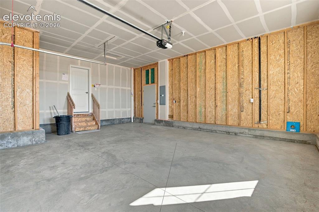 Image 46 of 50: Multi-car garage featuring a concrete floor, exposed structural wall framin