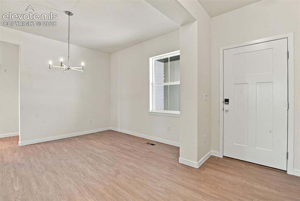 Image 5 of 50: Interior space featuring wood-finish flooring, a multi-arm modern chandelie