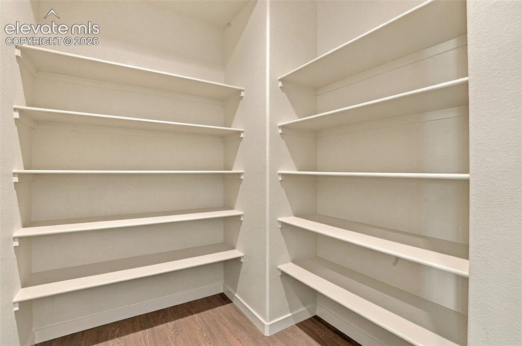 Image 6 of 50: Built-in storage pantry featuring multiple tiers of painted shelving and wo