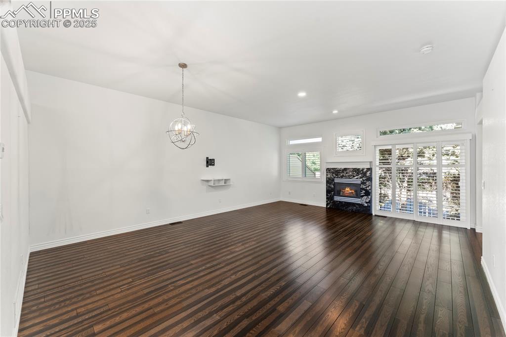 Image 11 of 50: Unfurnished living room with recessed lighting, dark wood-style floors, a h