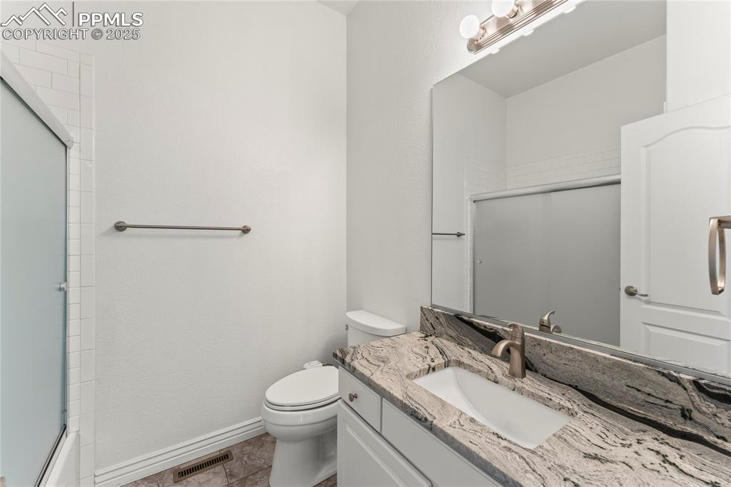 Image 13 of 50: Bathroom with vanity and shower / bath combination with glass door