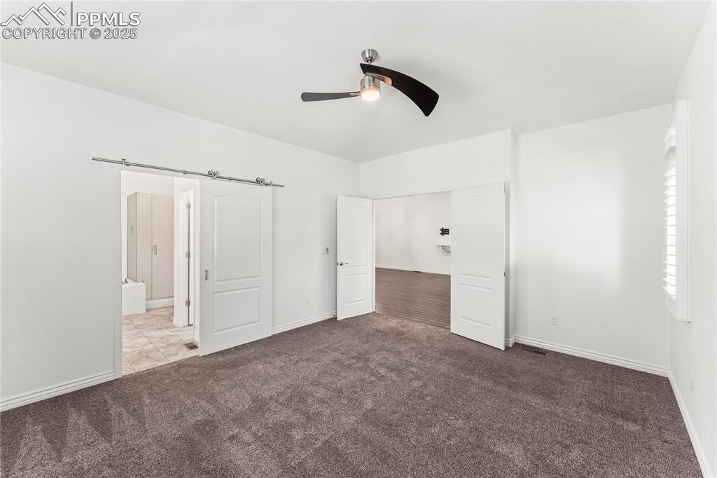 Image 19 of 50: Unfurnished bedroom with carpet flooring, ceiling fan, and vaulted ceiling