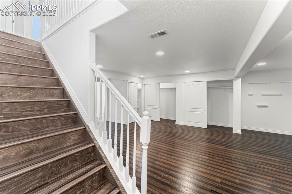 Image 29 of 50: Stairs with recessed lighting and wood finished floors