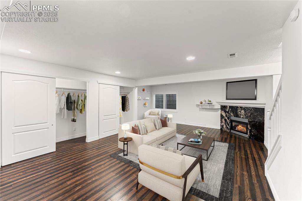 Image 34 of 50: Virtually staged living area with dark wood-style flooring, a high end fire