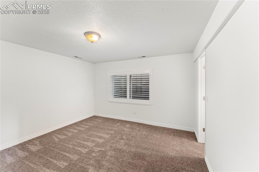 Image 35 of 50: Unfurnished room featuring carpet floors and a textured ceiling