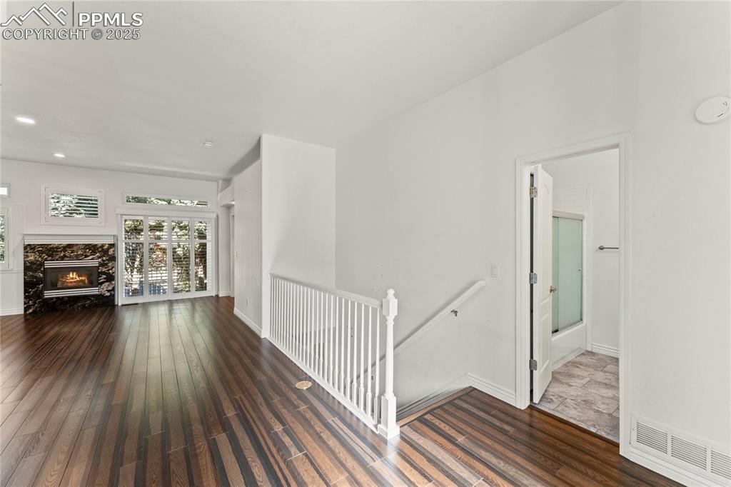Image 5 of 50: Living room featuring wood finished floors, a fireplace, and recessed light