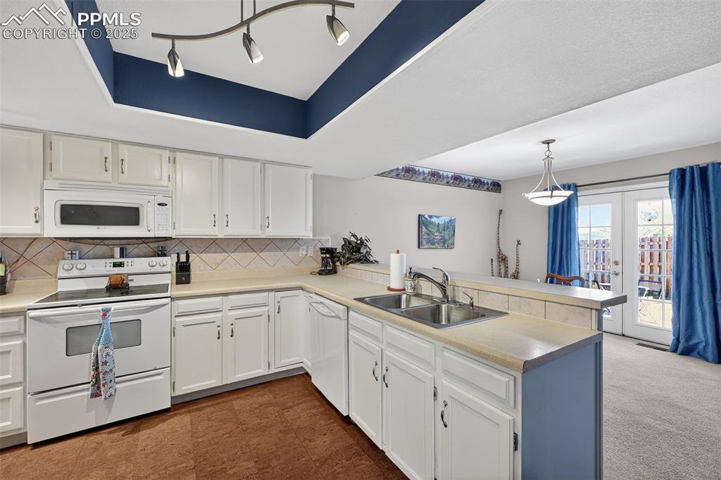 Image 13 of 27: Pan ceiling for architectural interest and the cork floors are soft on the 