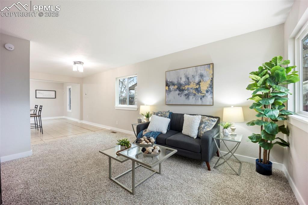 Image 5 of 33: Living room featuring baseboards and light carpet