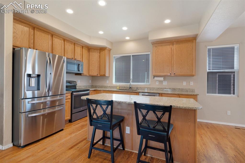 Image 15 of 46: Kitchen featuring stainless steel appliances, recessed lighting, light ston