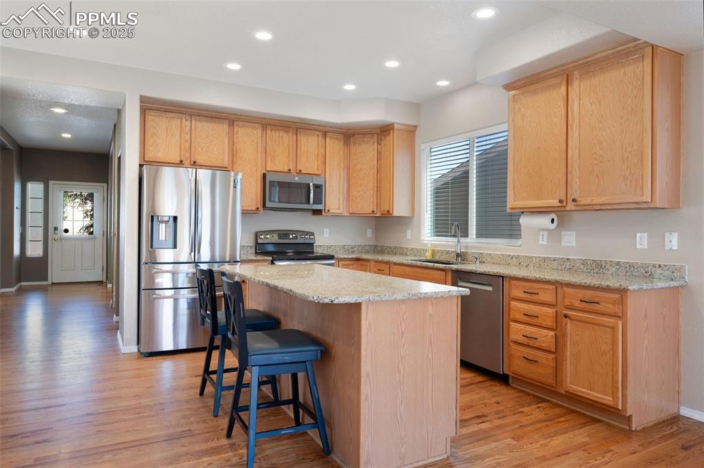 Image 16 of 46: Kitchen with a center island, dishwasher, light wood-style flooring, light