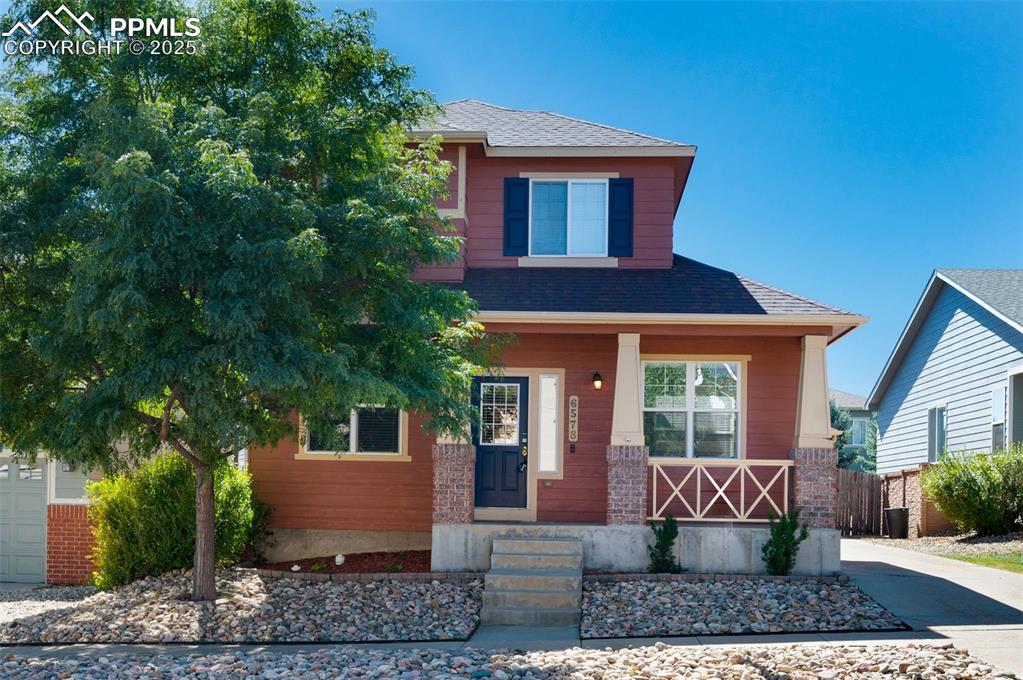 Image 2 of 46: View of front facade featuring covered porch, roof with shingles, and a gar