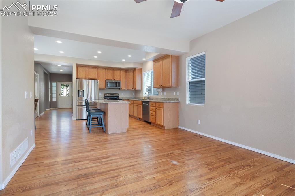 Image 23 of 46: Carpeted empty room with a tray ceiling, ceiling fan, and a decorative wall