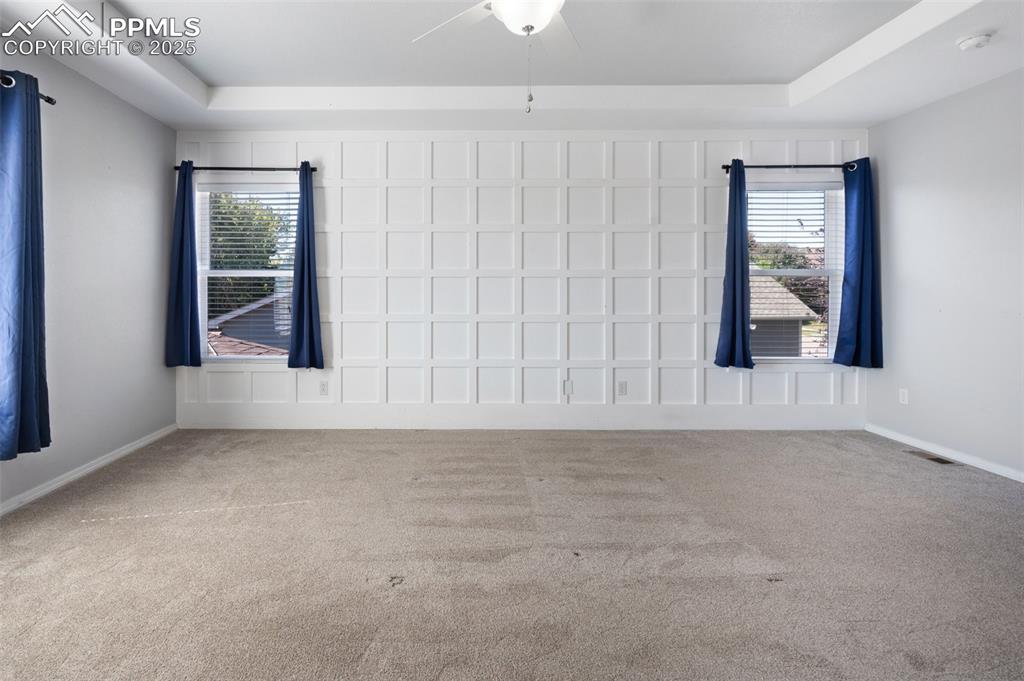 Image 26 of 46: Unfurnished bedroom featuring connected bathroom, a raised ceiling, light c