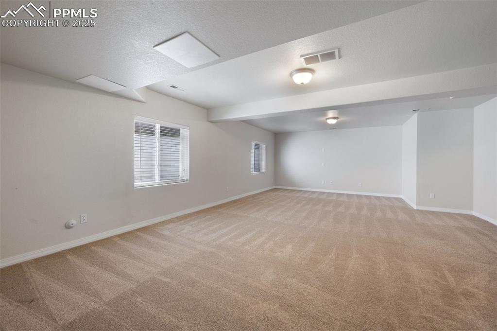 Image 39 of 46: Below grade area featuring light colored carpet and baseboards