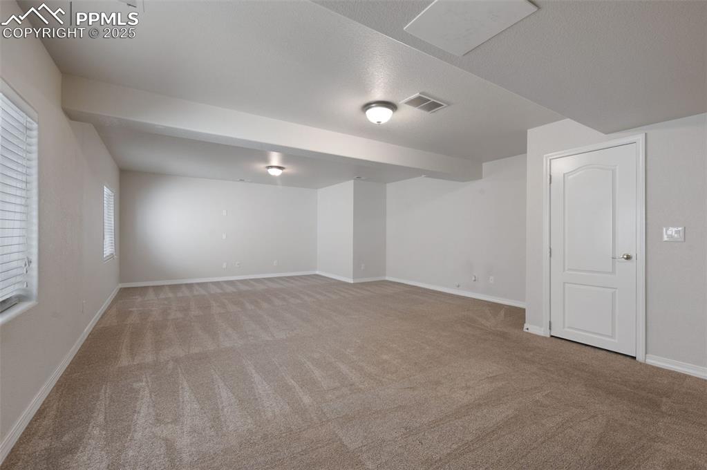 Image 40 of 46: Spare room with baseboards and light colored carpet