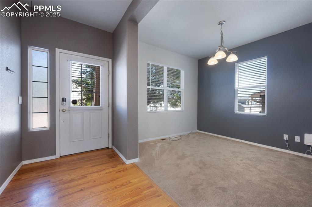 Image 7 of 46: Foyer with light wood finished floors and a chandelier
