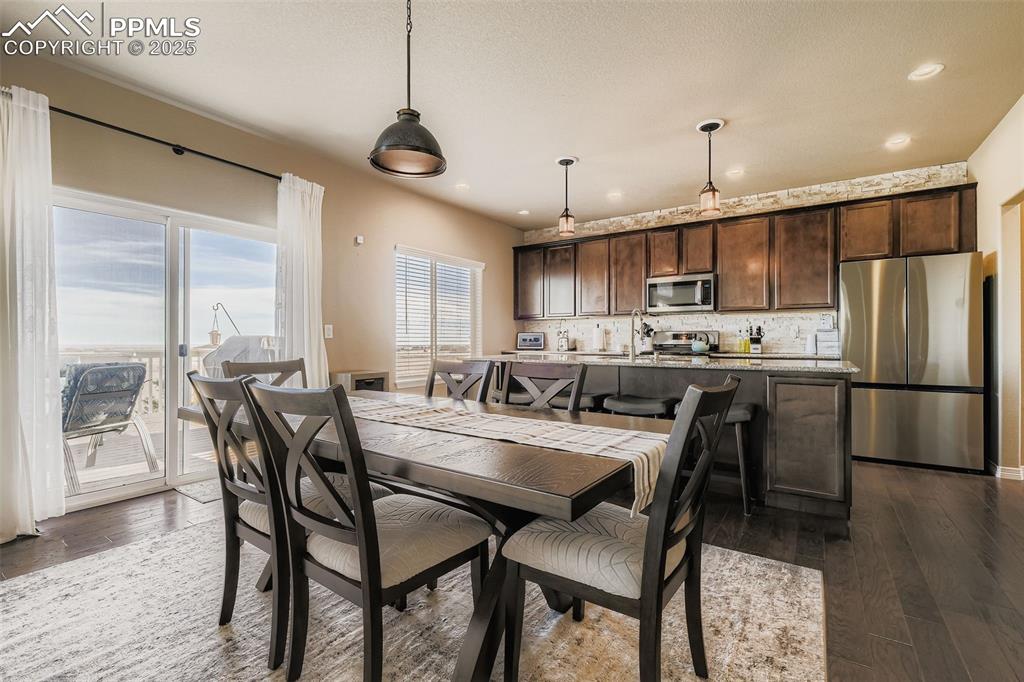 Image 12 of 35: Dining area with dark wood-style flooring and recessed lighting