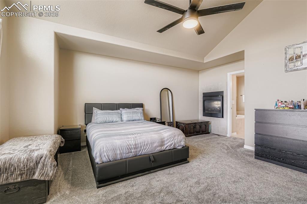 Image 15 of 35: Bedroom with carpet flooring, vaulted ceiling, connected bathroom, a ceilin