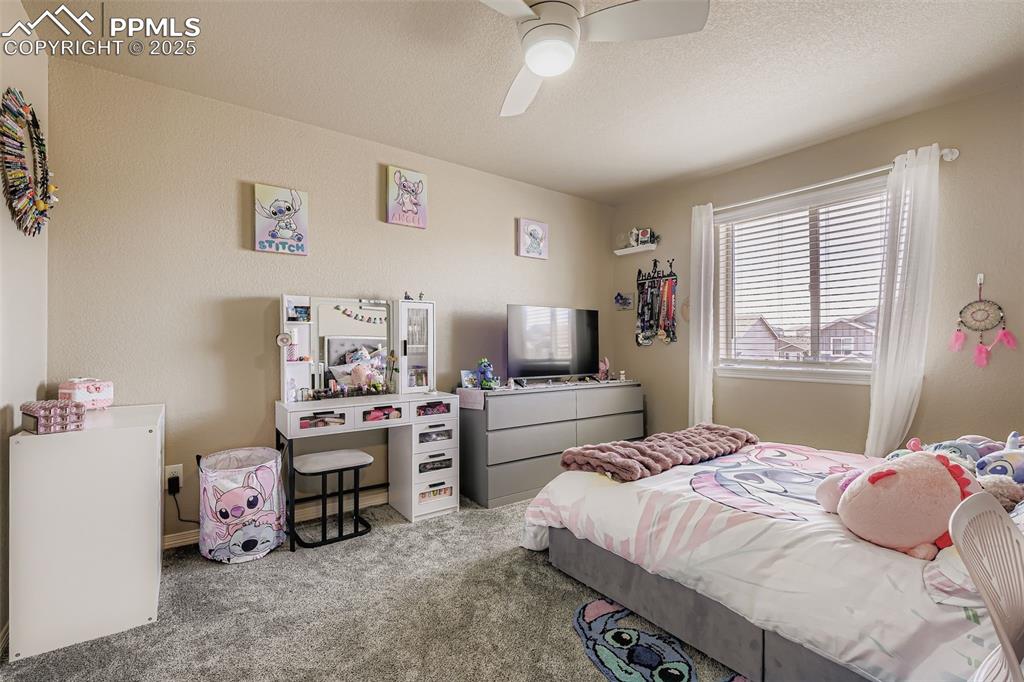 Image 19 of 35: Bedroom with carpet floors, a ceiling fan, and a textured ceiling