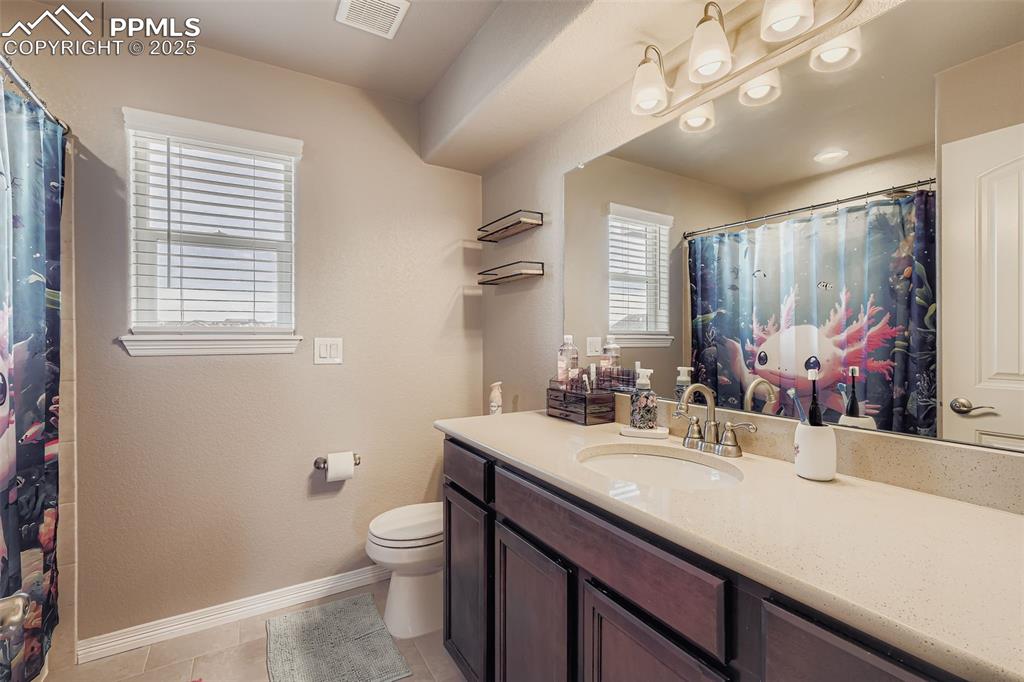 Image 20 of 35: Bathroom with vanity, a shower with curtain, light tile patterned floors, a