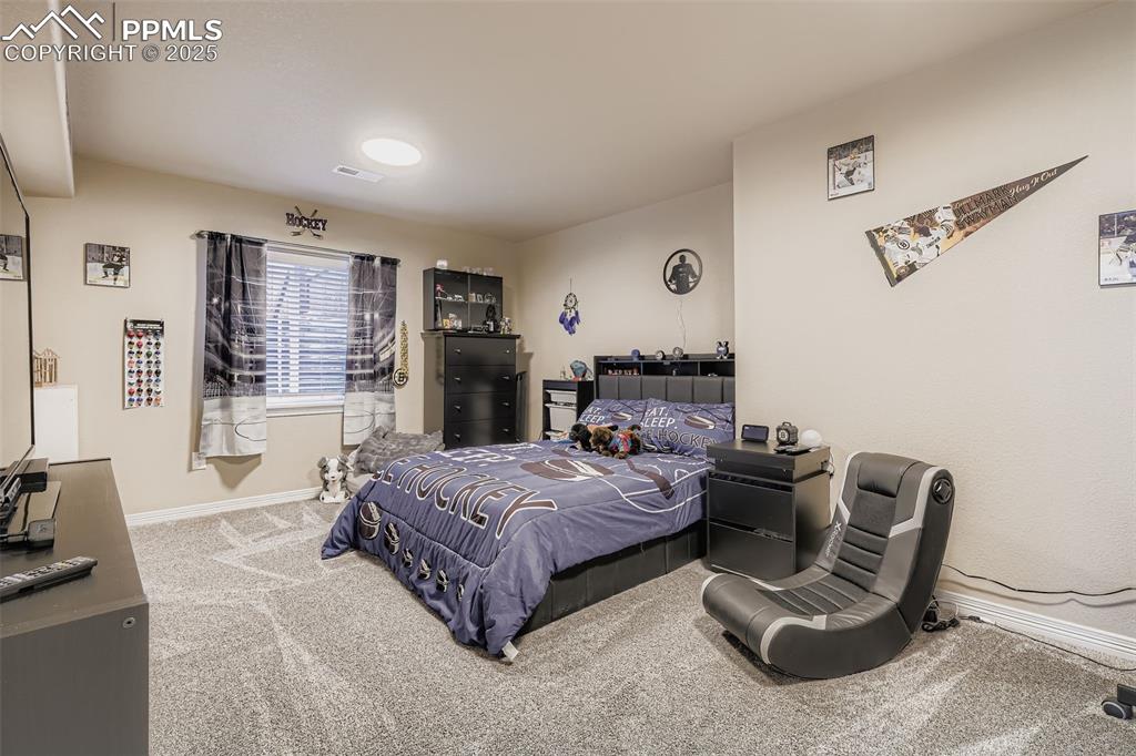 Image 25 of 35: Bedroom with baseboards and light colored carpet