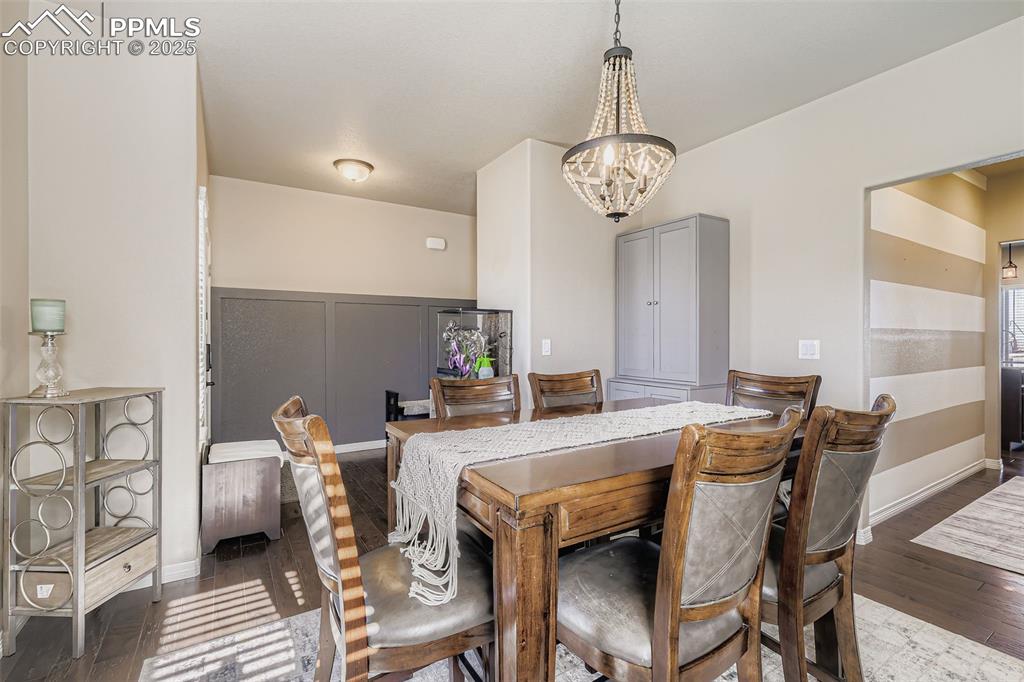 Image 7 of 35: Dining space featuring dark wood finished floors and a chandelier