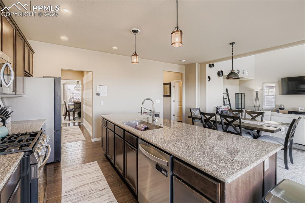 Image 9 of 35: Kitchen with dark brown cabinets, appliances with stainless steel finishes,