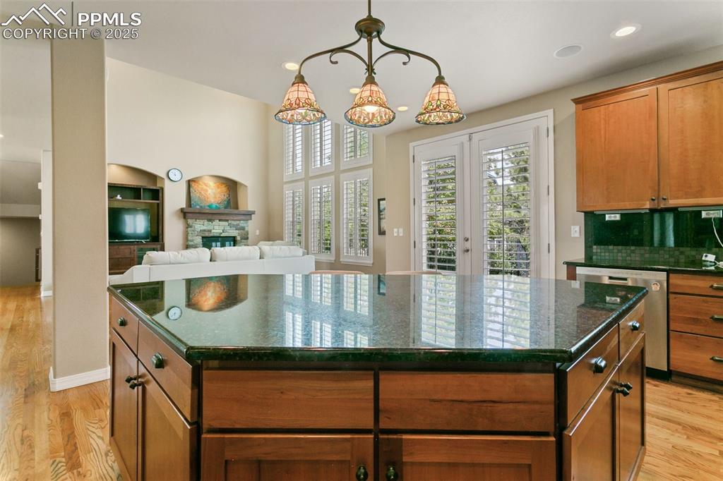 Image 14 of 37: Kitchen featuring brown cabinets, light wood finished floors, a center isla