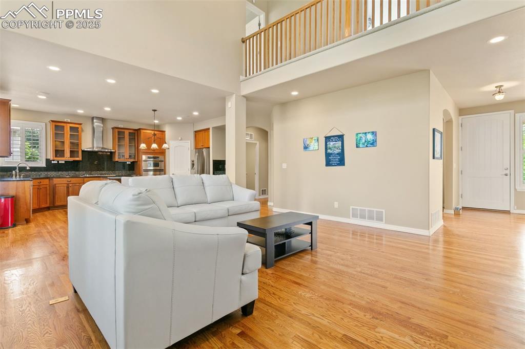 Image 6 of 37: Living area featuring recessed lighting, arched walkways, light wood finish