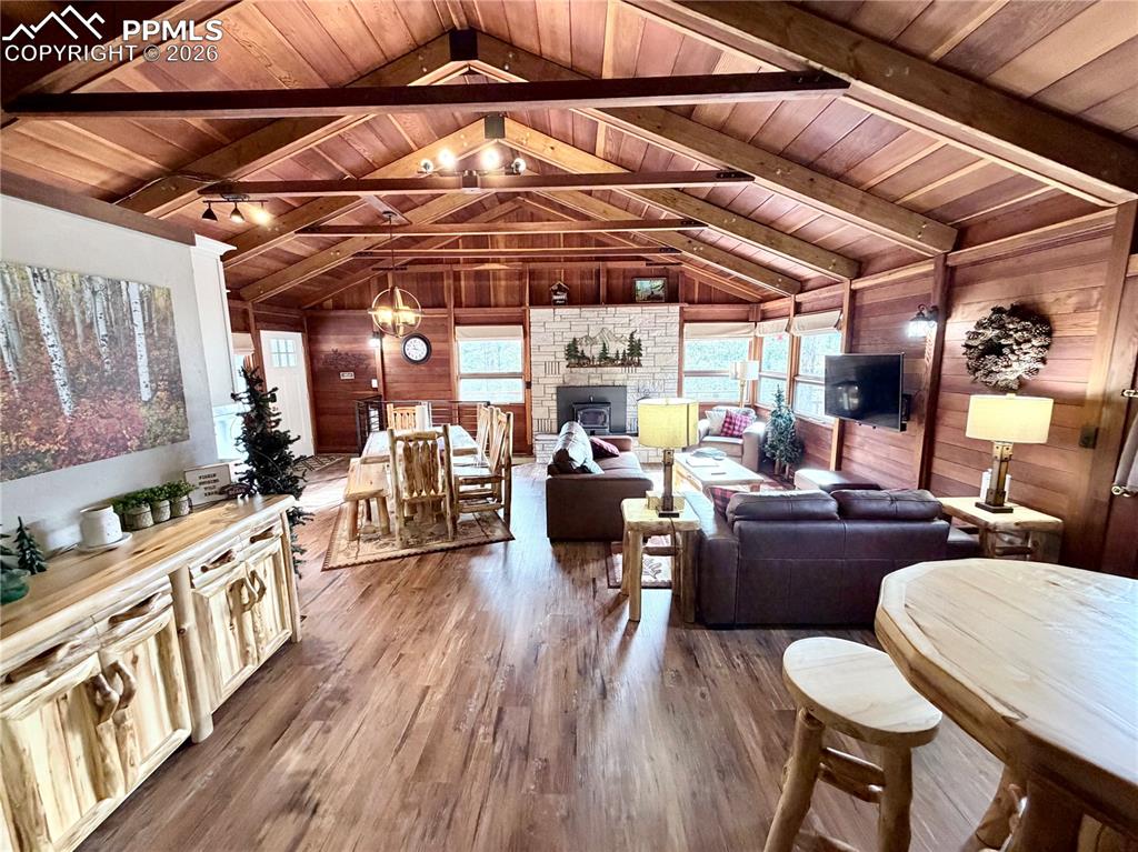 Image 10 of 20: Living room featuring wood ceiling, wood walls, dark wood-type flooring, a 