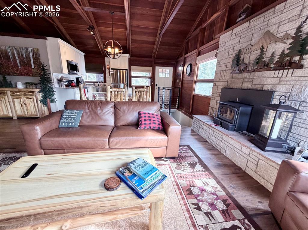 Image 3 of 20: Living room with a wood ceiling with exposed beams, wood finished floors, a