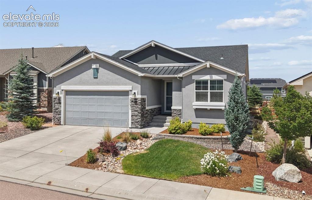 Image 1 of 37: Stucco and stone exterior featuring a 3 car tandem garage, dark shingle roo