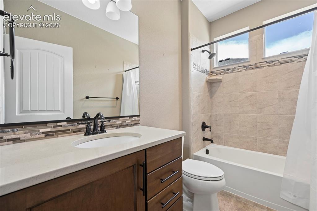 Image 15 of 37: Bathroom featuring a single vanity with stone-finish countertop, undermount
