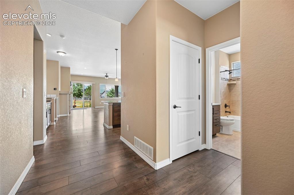 Image 2 of 37: Wood-finish flooring extending from the entryway into an open-concept livin