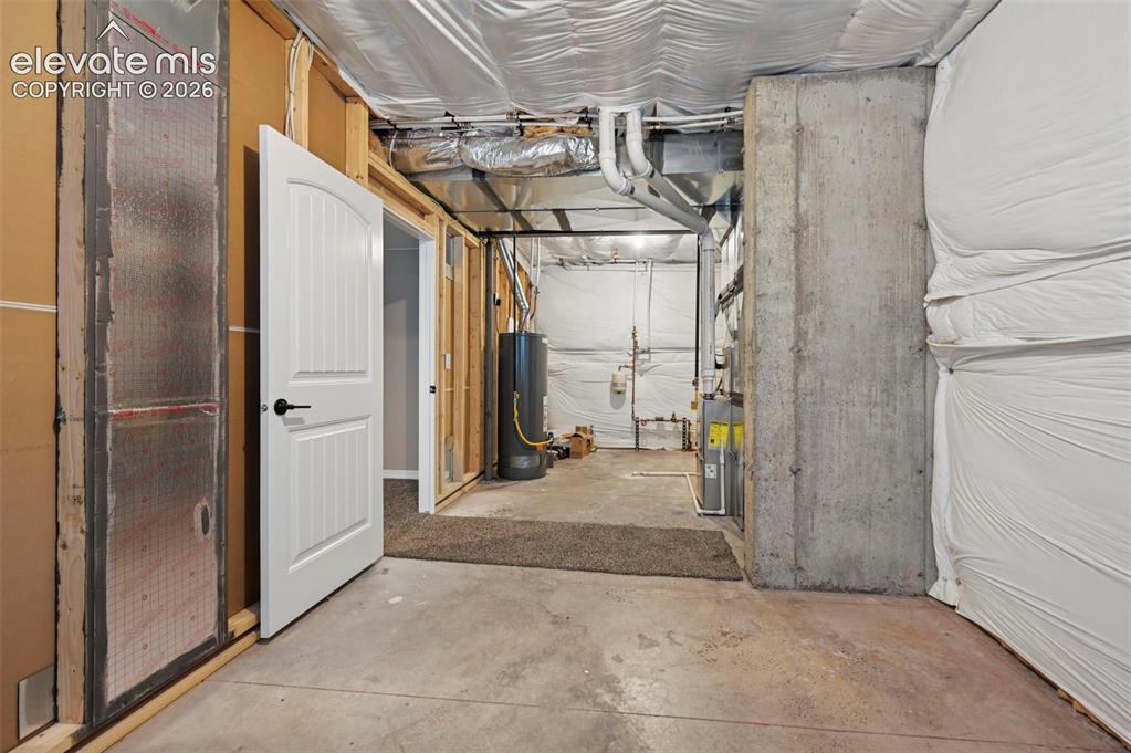 Image 21 of 37: Unfinished basement space featuring concrete flooring, exposed ceiling util
