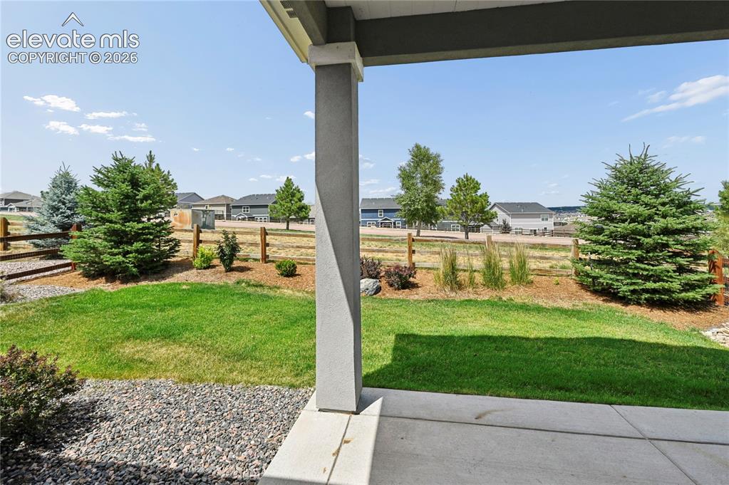 Image 23 of 37: Covered patio & fully fenced yard backing to common space.