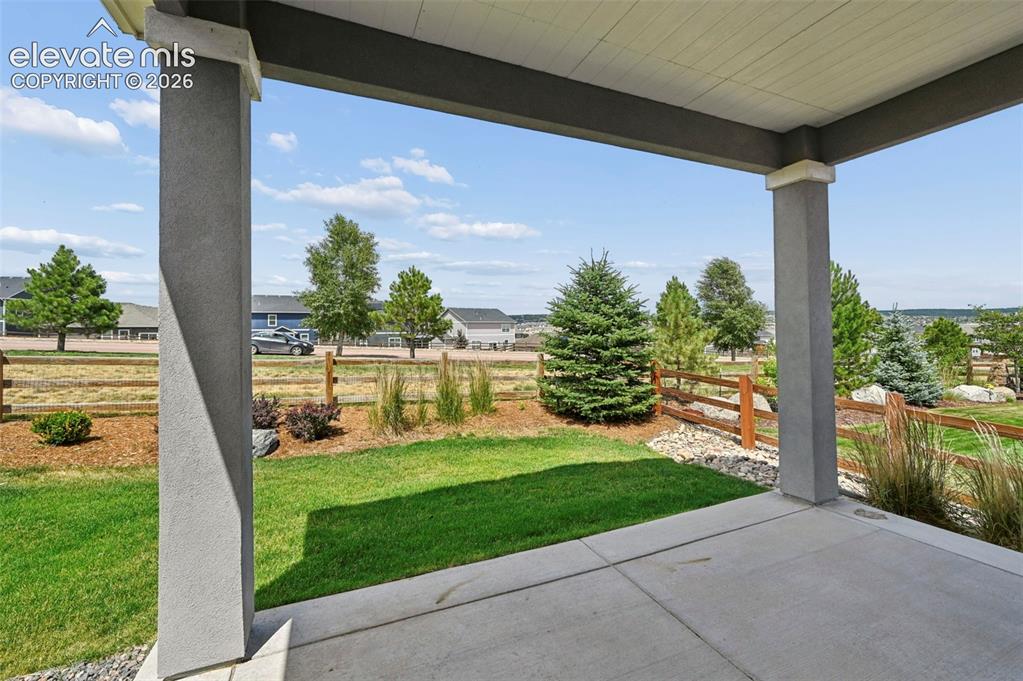 Image 24 of 37: Covered patio featuring a concrete surface, fully fenced yard and backing t
