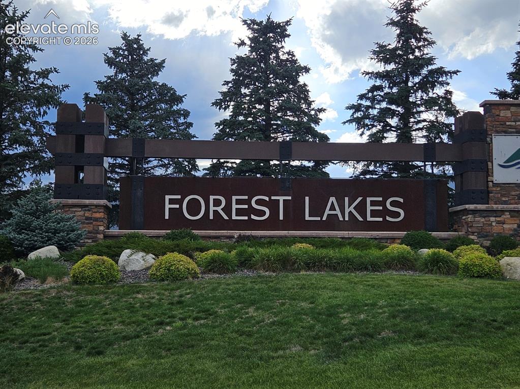 Image 25 of 37: Stone and wood-finish entry monument with "FOREST LAKES" lettering