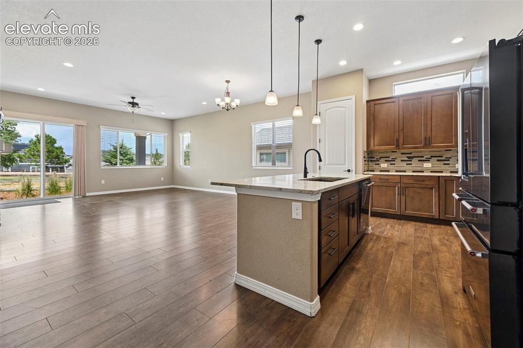 Image 3 of 37: Open-concept kitchen and living area featuring wood-finish flooring, recess