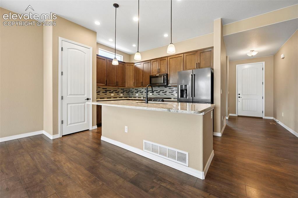 Image 6 of 37: Kitchen featuring wood-finish flooring, recessed lighting, and pendant ligh