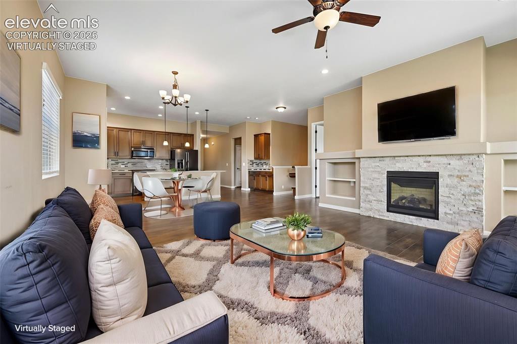 Image 7 of 37: Open-concept living space featuring wood-finish flooring, a stone-faced fir