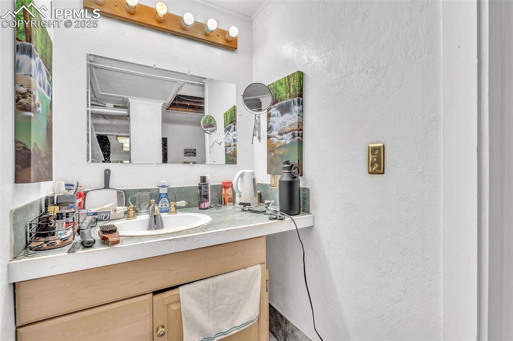 Image 25 of 49: Bathroom with a textured wall and vanity