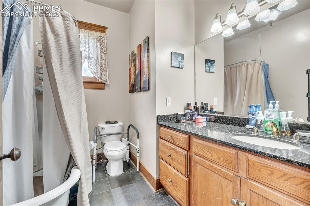 Image 28 of 49: Bathroom featuring vanity, tile patterned floors, and curtained shower