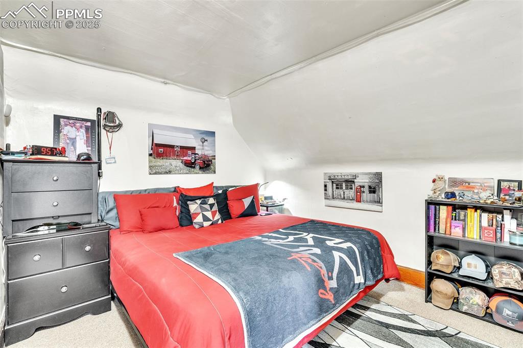 Image 31 of 49: Carpeted bedroom with lofted ceiling