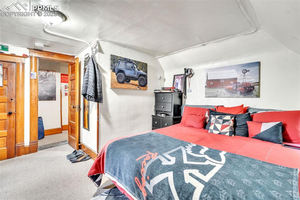 Image 32 of 49: Carpeted bedroom featuring lofted ceiling