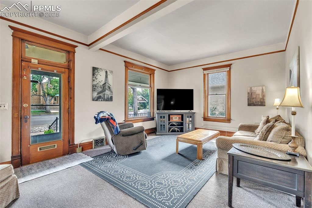 Image 5 of 49: Living room with healthy amount of natural light, carpet floors, and beamed